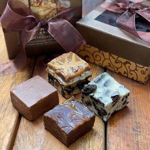 4 squares of fudge in front of a decorative box