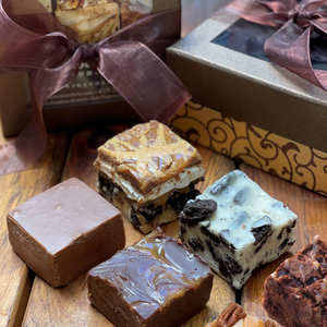 6 squares of fudge in front of a decorative box