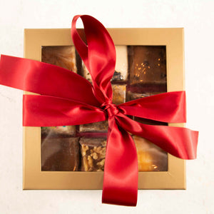 9 squares of fudge inside a decorative box with a red bow